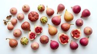 Fresh figs collection with whole and sliced fruits showing pink flesh and seeds, arranged on white background for culinary and healthy eating concepts.