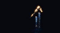 Glowing number one symbol combining sparkler light trails and blue glitter particles against dark background, creating magical festive effect.