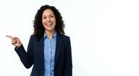 Professional Hispanic businesswoman in navy suit pointing and smiling on white background, isolated for corporate presentations and marketing materials.