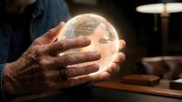 Mature man with dark skin holding glowing crystal ball in hands, fortune telling and divination concept for mystical services and spiritual guidance.