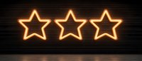 Glowing orange neon star signs on dark brick wall background, modern illuminated decoration for nightclub, bar, or restaurant interior design.