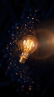 Glowing vintage light bulb with magical bokeh particles and warm filament against dark background for creative innovation and inspiration concepts.
