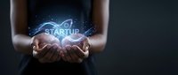 Entrepreneur holding glowing startup concept with digital light effects, symbolizing new business innovation and entrepreneurial vision for corporate growth.