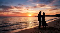Silhouetted couple standing together on sandy beach at sunset, watching golden sun descend over calm ocean waters during romantic evening. Use for travel, relationships, lifestyle content.