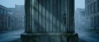 Ancient weathered stone column base in misty urban street scene with classical architecture and atmospheric fog creating moody historical ambiance.