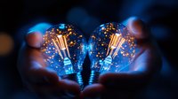 Glowing vintage light bulbs with filaments held in hands against dark background, creating magical atmosphere with blue illumination and bokeh effect.