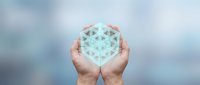 Hands holding glowing geometric hexagon structure against blurred background, representing innovation, technology, and digital transformation for business concepts.