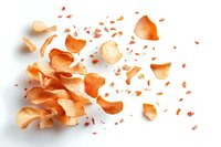 Scattered dry onion skin peels and fragments on white background creating natural organic pattern with warm orange tones and delicate texture.