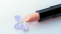 Nude pink lipstick with delicate purple flower on white background, minimalist beauty cosmetics composition for makeup and skincare advertising.
