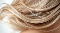 Flowing blonde hair strands with natural highlights and lowlights creating dynamic movement and texture for beauty and haircare concepts.