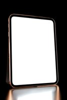 Modern tablet device with rose gold frame and blank white screen on dark background with reflection, isolated mockup for digital presentation.