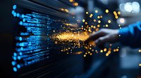 Digital transformation concept with glowing code and golden light particles emerging from computer screen, symbolizing technological breakthrough and data innovation.