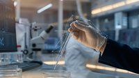 Laboratory scientist conducting chemical analysis with test tube in modern research facility for pharmaceutical development and scientific experimentation.