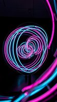Glowing neon spiral tubes in magenta and cyan create a mesmerizing abstract vortex against a dark background, perfect for modern design and tech projects.