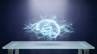 Glowing digital brain hologram with neural network connections floating above modern white table against dark background for AI technology concepts.