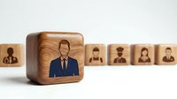 Wooden cube with businessman icon stands out from row of employee blocks representing leadership selection and human resources management in corporate environment.