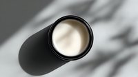 Minimalist black container with white cream cosmetic product casting soft shadow, perfect for luxury skincare advertising.