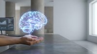 Holographic brain floating above open palm in modern office space showcasing artificial intelligence, neuroscience technology and digital innovation concepts.