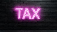 Glowing pink neon TAX sign mounted on dark brick wall background, creating modern urban nighttime atmosphere for financial and business concepts.