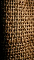 Natural burlap fabric texture with woven jute fibers in warm brown tones, rustic material background for eco-friendly packaging and craft projects.