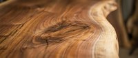 Close-up of natural wood grain texture with warm brown tones and organic swirling patterns, suitable for backgrounds and design projects.
