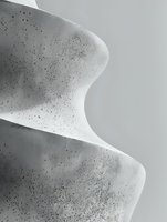 Abstract black and white architectural detail showing smooth curved concrete surfaces with textured speckled finish against light background, creating minimalist composition.