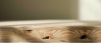 Empty wooden table surface with natural wood grain texture and knots, blurred background for product display and presentation purposes.