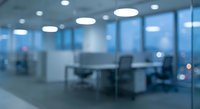 Modern blurred office interior with glass partitions, desks and chairs creating professional workspace atmosphere for business presentations.