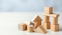 Natural wooden building blocks arranged on white surface for educational play and creative construction activities.