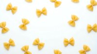 Yellow pasta bow ties arranged on white background, isolated and ready for design use on packaging, menus, cooking blogs, recipe websites, food labels, and culinary marketing materials.