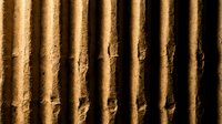 Corrugated cardboard texture with vertical ridges and natural brown color showing detailed fiber structure and manufacturing lines.