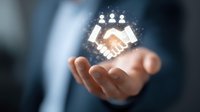 Digital handshake hologram floating above businessman's palm, symbolizing virtual partnership and technology-driven business collaboration in corporate environment.