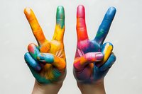 Colorful painted hands making peace signs against white background, showcasing vibrant mix of yellow, blue, red, and green paint in artistic expression of joy and unity.