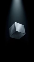 Metallic cube floating in dramatic spotlight beam on dark background for modern design projects and creative presentations.