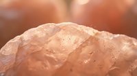 Close-up macro shot of pink Himalayan rock salt crystals with natural texture and mineral formations, perfect for culinary and wellness content.