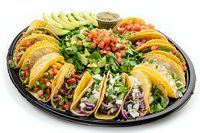 Mexican street tacos platter with variety of fillings, topped with fresh avocado, cilantro, onions and lime on black serving tray. Traditional authentic cuisine.