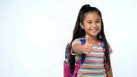 Young Asian girl student with backpack giving thumbs up gesture, smiling confidently in colorful striped shirt on white background for back to school designs.