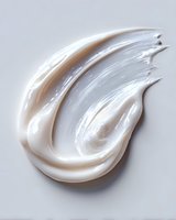 Creamy white moisturizer smear with glossy texture on light background, showcasing skincare product consistency for cosmetic advertising.
