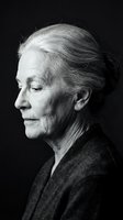 Senior woman with gray hair in profile, wearing dark cardigan against black background. Monochrome portrait for editorial, healthcare, aging, and lifestyle content.
