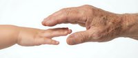 Young and elderly hands reaching toward each other symbolizing connection, care, and intergenerational support on white background.