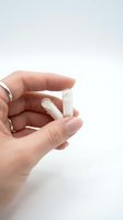 Woman hand holding white medical pills capsules on clean background for healthcare and pharmaceutical advertising.