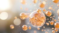 Glowing orange spheres with sparkles floating in soft blurred space, magical bubbles with golden light effects against gray background for wellness designs.