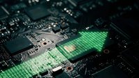 Green digital arrow pointing upward on computer circuit board representing technology growth, data processing, and electronic innovation in modern computing systems.