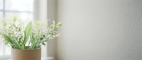Fresh lily of the valley flowers in ceramic vase on windowsill with soft natural light creating peaceful home decor atmosphere for spring interior design.