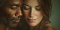 Intimate portrait of loving interracial couple with eyes closed, African American man and Caucasian woman sharing tender moment in warm natural light.