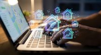 Smart home automation technology concept with digital house icons and WiFi symbols floating above laptop keyboard for IoT property management solutions.