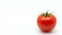 Fresh red ripe tomato isolated on white background for healthy cooking and nutrition concepts.