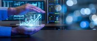 Hands holding glowing financial growth chart in data center environment with server racks and digital displays, representing business analytics and technology investment.