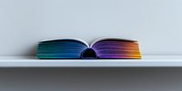 Open book with rainbow colored pages against white background creates minimalist composition showing gradient spectrum from blue to purple and orange tones.