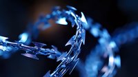 Sharp razor wire coiled in dramatic blue lighting creates moody atmosphere with selective focus and shallow depth of field, highlighting security and boundary concepts.